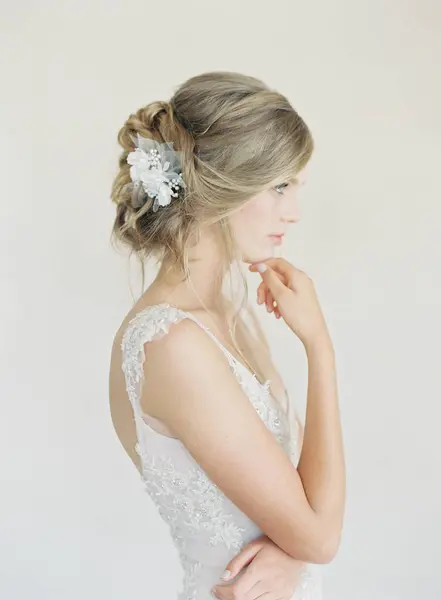 Femme en robe de mariée avec la main au menton — Photo