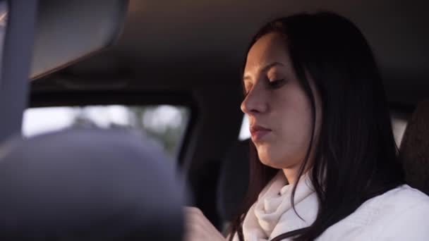 Женщина наносит макияж в машине — стоковое видео