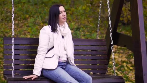 Γυναίκα ταλαντώσεις σε μια κούνια σε ένα πάρκο — Αρχείο Βίντεο