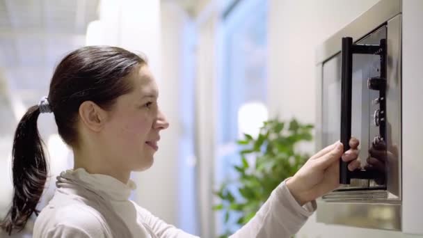 Mujer cocinando con horno microondas — Vídeos de Stock