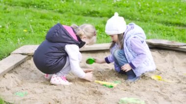 dwie dziewczyny bawić się w piaskownicy