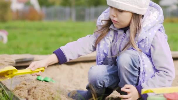 Дівчина грає в пісочниці — стокове відео