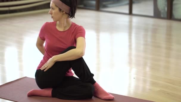 Счастливая женщина делает упражнения на коврике — стоковое видео