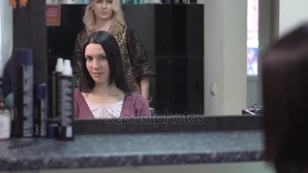 Женщина с новой прической в салоне красоты, смотрящая в зеркало — стоковое видео