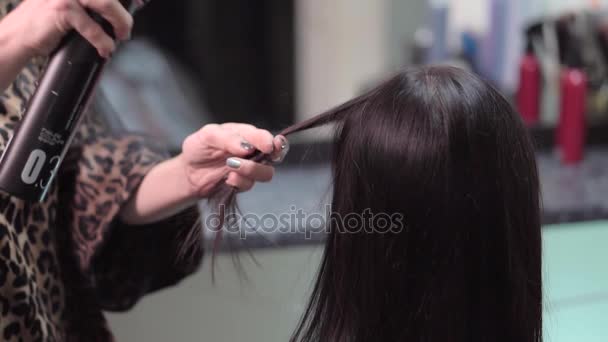 Женский парикмахер наносит спрей на волосы клиентов — стоковое видео