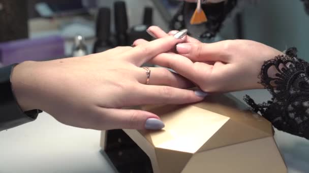 Primer plano de una mujer haciéndose manicura de uñas por un esteticista — Vídeos de Stock