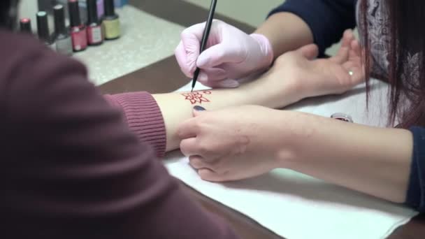 Konstnären tillämpa henna tatuering på kvinnor händer — Stockvideo