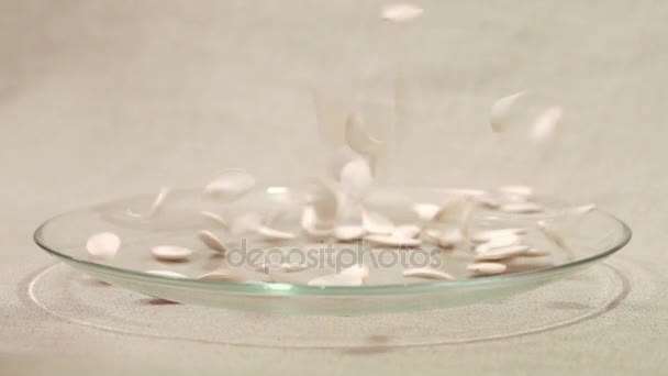 Гарбузове насіння падає в скляну миску — стокове відео