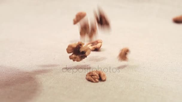 Сухие сырые ореховые ядра падают на льняную ткань — стоковое видео