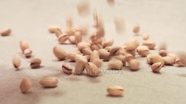 Pimpernoten (pistaches) vallen op een linnen stof — Stockvideo