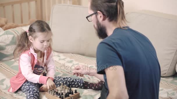 Pikkutyttö oppii pelaamaan shakkia. — kuvapankkivideo