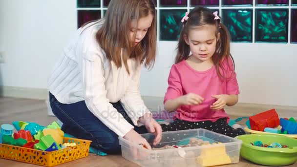 Duas meninas brincando com areia cinética em casa — Vídeo de Stock