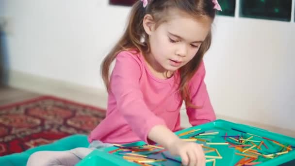 Meisje spelen met kleurrijke houten stokken op de verdieping — Stockvideo