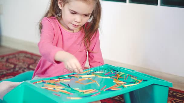 Fille jouer avec des bâtons de bois colorés sur le sol — Video