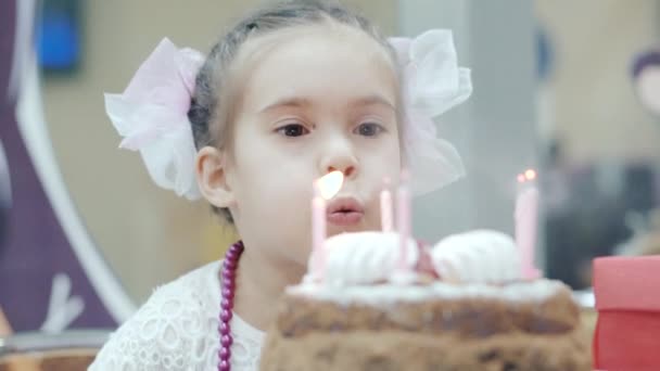 LITTLE GIRL BLOWING CANDLES ON BIRTHDAY CACE — Stock video