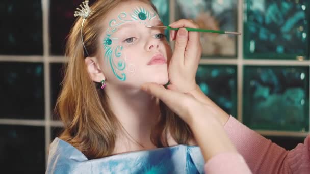 Painter makes butterfly shape at girls face — Stock Video