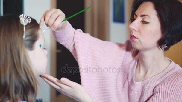 Painter makes butterfly shape at girls face — Stock Video