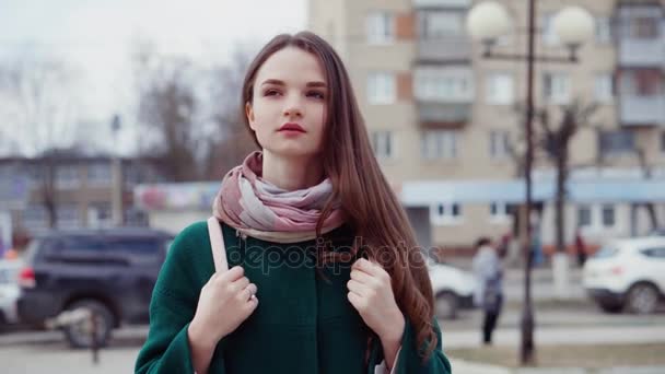 Νεαρή γυναίκα μελαχρινή μακρυμάλλης σε παλτό σε δρόμο της πόλης — Αρχείο Βίντεο