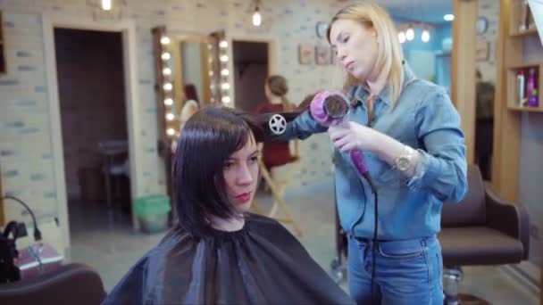 Mulher recebendo novo corte de cabelo por cabeleireiro no salão — Vídeo de Stock