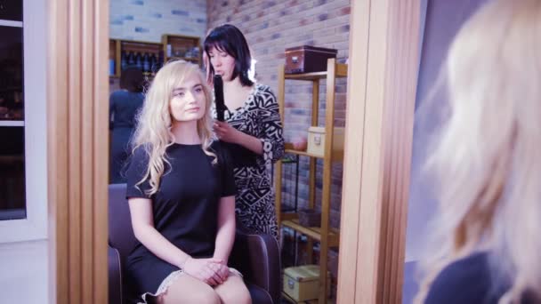 Mujer consiguiendo nuevo corte de pelo por peluquería en el salón — Vídeo de stock