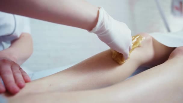 Gyantázás womans lábát szépségszalonban kozmetikus — Stock videók