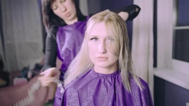 Mujer joven consiguiendo nuevo corte de pelo por peluquería en el salón o en casa . — Vídeo de stock
