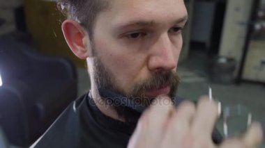 Genç bir adamın saç ve sakal makas kuaför dükkanında kekemelik.