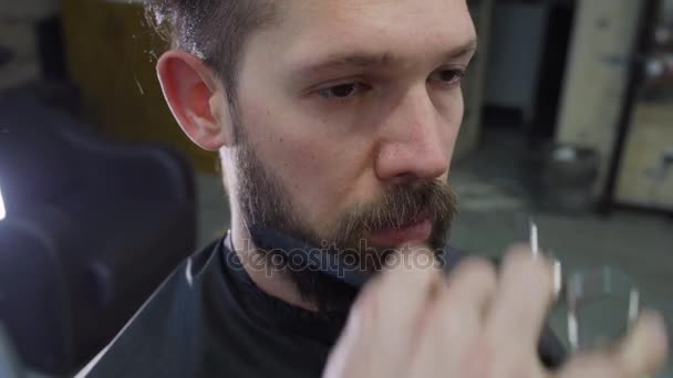Un jeune homme cheveux et barbe coupés par des ciseaux dans le salon de coiffure . — Video