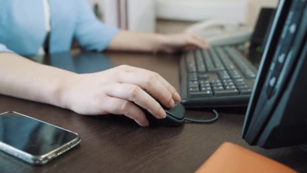 Mujer de negocios sentada en la oficina y utiliza el ratón de la computadora . — Vídeo de stock