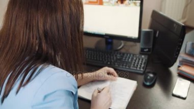 Mavi bir ceket ve iş kadını esmer günlüğüne ofiste masa üzerine yazıyor.