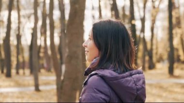 Mutlu genç oldukça esmer kadın gülümseyerek ve sonbahar parkta kamera poz.