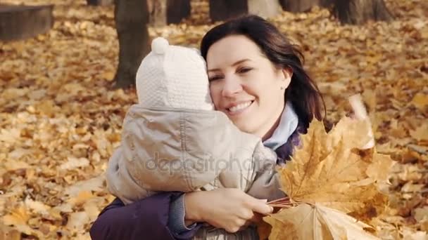 Lycklig kvinna kramar hennes lilla dotter i parken hösten. — Stockvideo