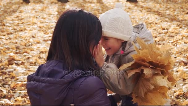 Niña feliz abrazando a su madre en el parque de otoño . — Vídeo de stock