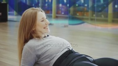 Yalan ve yapıyor mutlu sarışın genç ve güzel kadın spor salonunda böler.