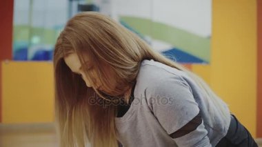 Spor salonunda germe egzersiz yaparak sarışın genç ve güzel kadın.