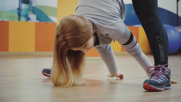 Loira muito jovem mulher fazendo a inclinação de alongamento no ginásio . — Vídeo de Stock