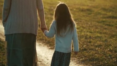 Anne ile kızı yürüyüş günbatımı kırsal yol.