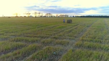 Anne ile kızı sarılma ve rustik sahada günbatımında çember.