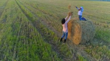 Küçük kız yýðýn üzerinde oturur ve annesine çöp atmak.
