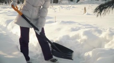 Genç kadın kar küreği banliyölerinde kışın kaldırır.