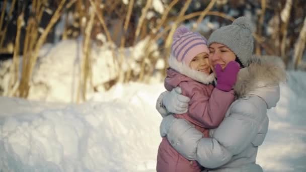 Ευτυχισμένη μαμά και κόρη αγκαλιά στα προάστια το χειμώνα. — Αρχείο Βίντεο