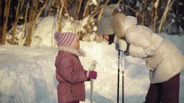 Mamá y su hija hablando antes de caminar nórdico en los suburbios en invierno . — Vídeos de Stock