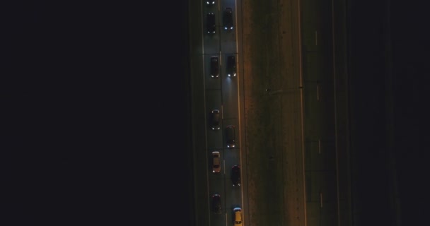 Cars are slowly riding on highway at night. Top aerial view. Traffic jam. — Stock Video