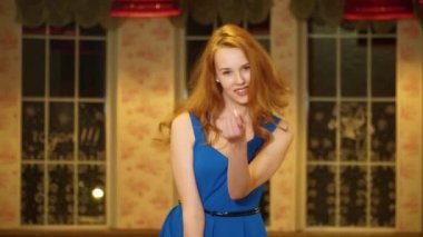 Kızıl saçlı, neşeli bakışlı, kameraya bakıp arayan güzel kız.