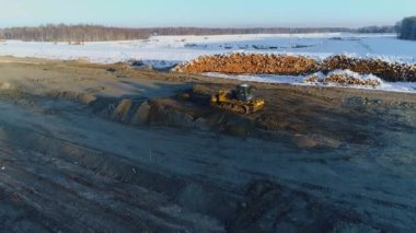 Buldozer kum seviyesinde, kışın yol yapıyor. Ormanların tahrip edilmesi, inşaat