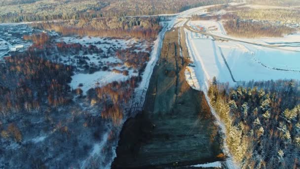 Costruzione autostradale in inverno. Deforestazione e sviluppo una strada di trasporto — Video Stock