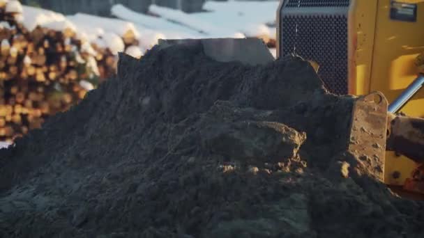 Bulldozer duwt zand, bouwt een weg in de winter. Ontwikkeling van een nieuwe snelweg — Stockvideo