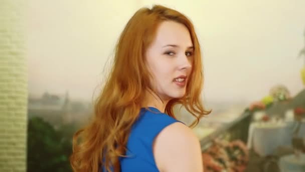 A bela garota sexy com cabelo vermelho e olhar brincalhão está girando e sorrindo — Vídeo de Stock