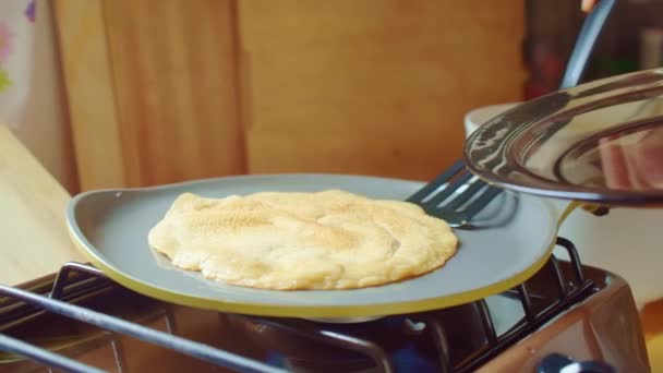 Cook legt gebackene leckere Pfannkuchen-Spatel von der Pfanne auf den Glasteller. Nahaufnahme. — Stockvideo