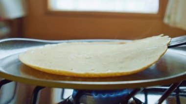 Aşçı, spatulayla birlikte harika fırında krep pişirir. Kapatın. Yavaşla